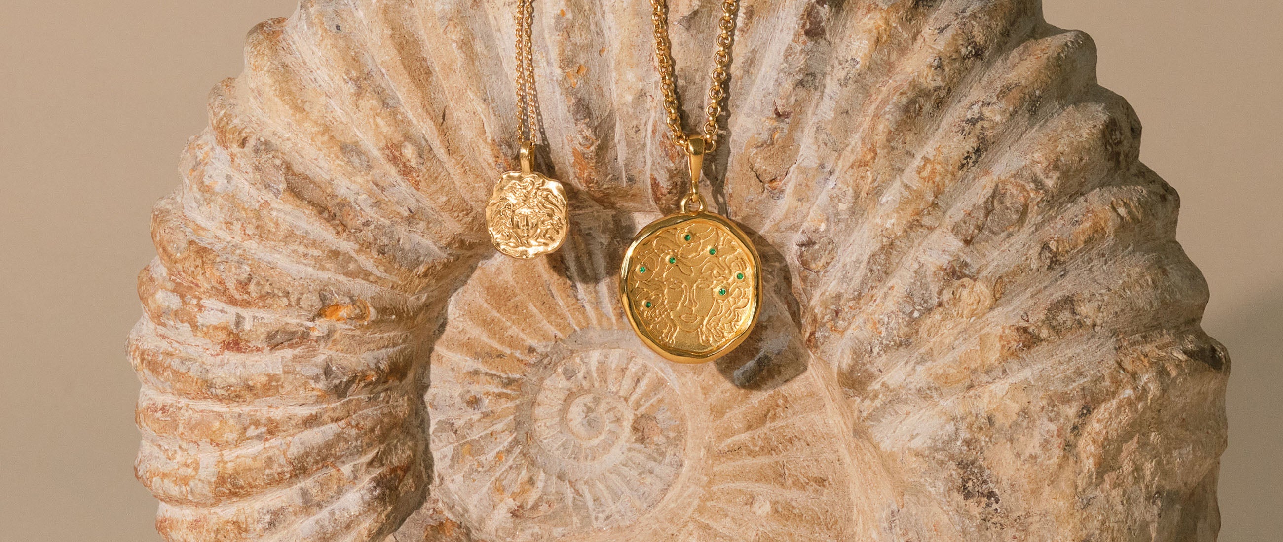 two gold necklaces on an ancient fossil