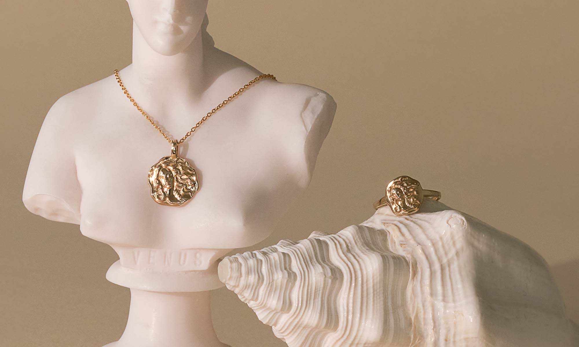 Aphrodite goddess necklace and ring in gold by Common Era, styled on a Venus bust with a shell